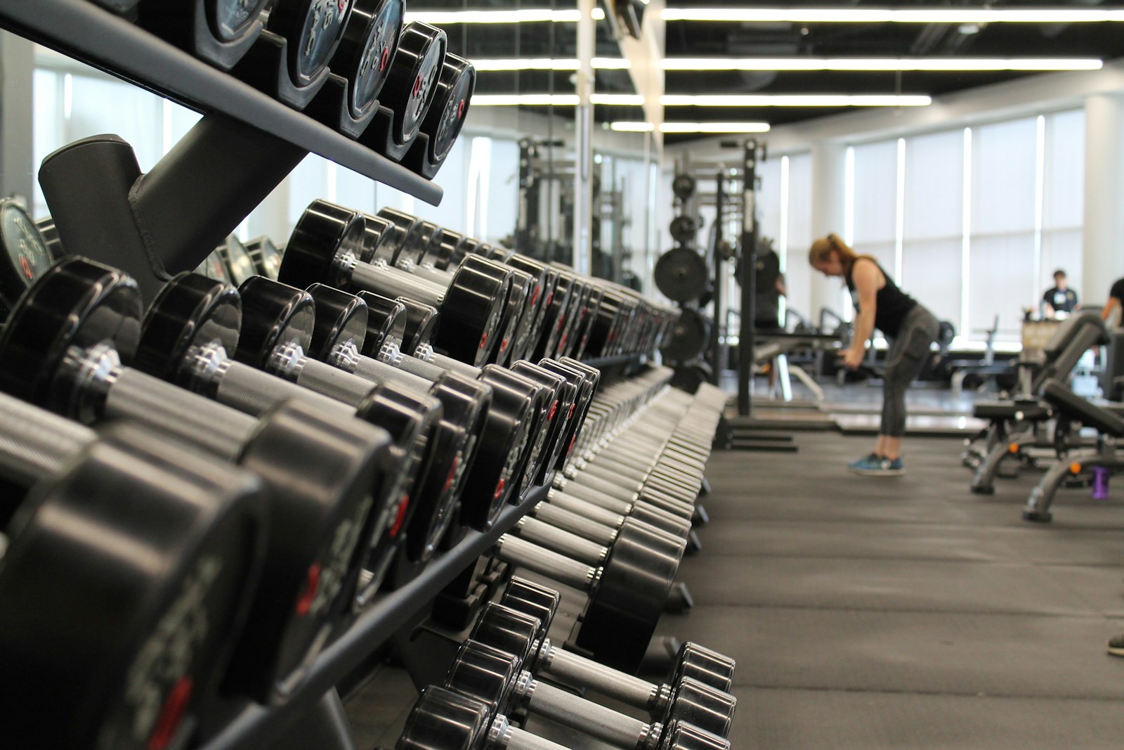 Lifter under a loaded barbell in a dark gym